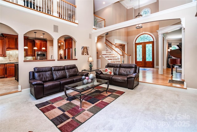 122 Sleepy Cove Trl, Mooresville, NC 28117 - living room with stairs, crown molding, light colored carpet, a high ceiling, and french doors