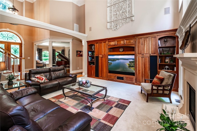122 Sleepy Cove Trl, Mooresville, NC 28117 - living room featuring a towering ceiling, decorative columns, a fireplace with flush hearth, carpet floors, and stairs