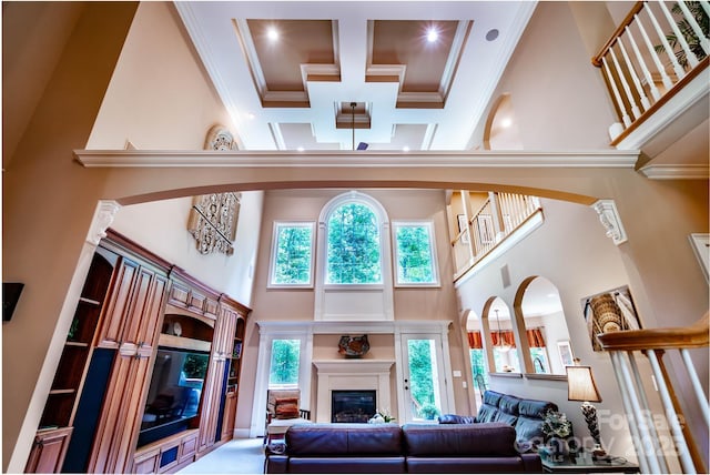 122 Sleepy Cove Trl, Mooresville, NC 28117 - living area with a towering ceiling, coffered ceiling, ornamental molding, beamed ceiling, and a glass covered fireplace