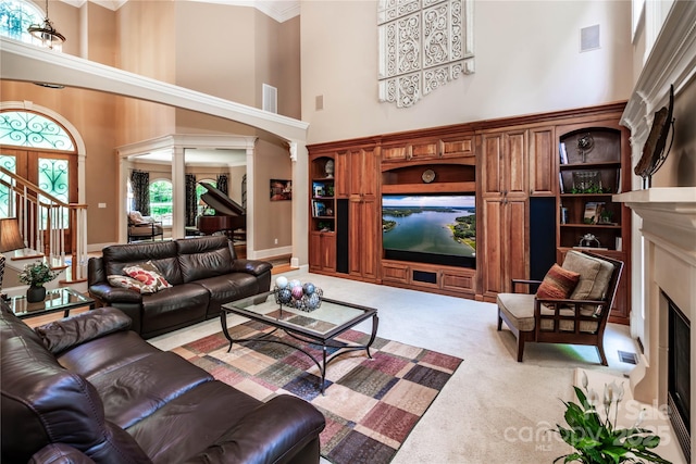 122 Sleepy Cove Trl, Mooresville, NC 28117 - carpeted living area featuring a high ceiling, a fireplace, decorative columns, and stairway