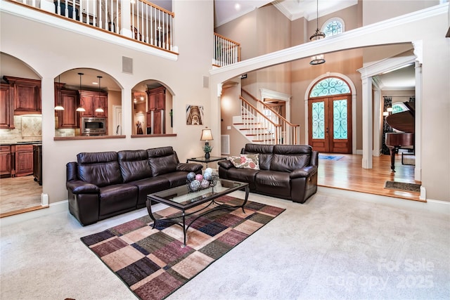 122 Sleepy Cove Trl, Mooresville, NC 28117 - living room featuring light carpet, stairway, a high ceiling, ornamental molding, and french doors