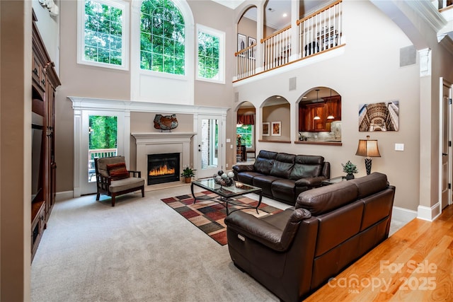 122 Sleepy Cove Trl, Mooresville, NC 28117 - living room with a glass covered fireplace, a high ceiling, plenty of natural light, arched walkways, and crown molding