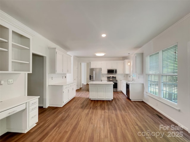 10319 Willingham Rd, Huntersville, NC 28078 - kitchen featuring stainless steel appliances, tasteful backsplash, light countertops, dark wood-style flooring, and crown molding