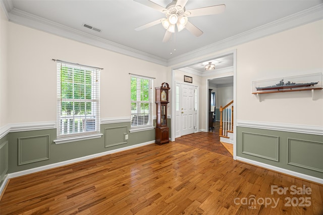 220 Glenville Dr, Fort Mill, SC 29715 - spare room featuring ornamental molding, stairs, wood finished floors, wainscoting, and ceiling fan