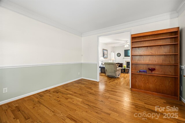 220 Glenville Dr, Fort Mill, SC 29715 - spare room with crown molding, a fireplace, wood finished floors, and ceiling fan
