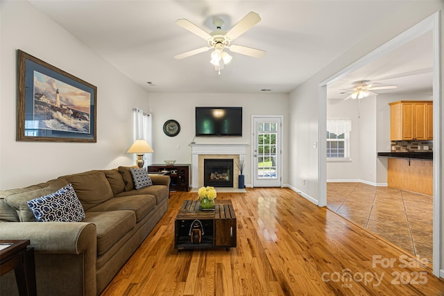 220 Glenville Dr, Fort Mill, SC 29715 - living room featuring ceiling fan, light wood finished floors, and a fireplace with flush hearth