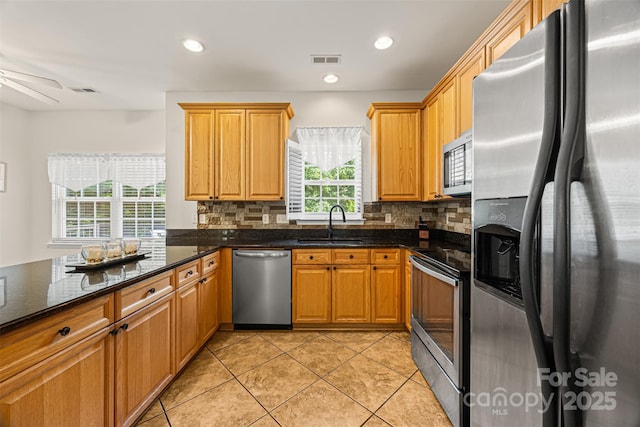 220 Glenville Dr, Fort Mill, SC 29715 - kitchen featuring stainless steel appliances, tasteful backsplash, light tile patterned floors, dark stone counters, and recessed lighting