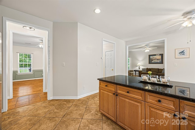 220 Glenville Dr, Fort Mill, SC 29715 - kitchen with a ceiling fan, light tile patterned floors, dark stone countertops, brown cabinetry, and recessed lighting