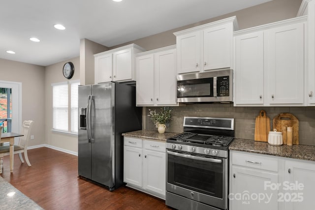 1919 Madeira Cir, Waxhaw, NC 28173 - kitchen featuring appliances with stainless steel finishes, dark wood-type flooring, tasteful backsplash, white cabinets, and recessed lighting
