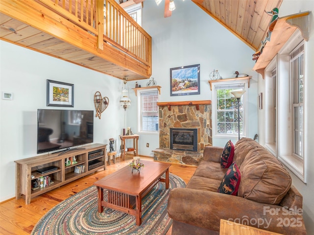 41 Trapper Ln, Waynesville, NC 28785 - living area featuring wood finished floors, healthy amount of natural light, wood ceiling, a stone fireplace, and high vaulted ceiling