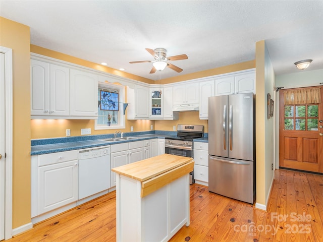 41 Trapper Ln, Waynesville, NC 28785 - kitchen featuring stainless steel appliances, a sink, under cabinet range hood, white cabinets, and light wood finished floors