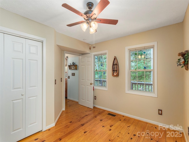 41 Trapper Ln, Waynesville, NC 28785 - unfurnished bedroom featuring light wood finished floors, baseboards, a closet, and ceiling fan