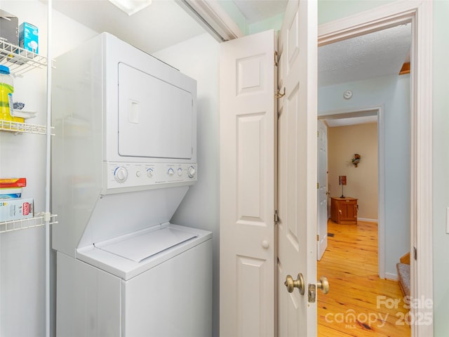 41 Trapper Ln, Waynesville, NC 28785 - washroom featuring stacked washer / drying machine, light wood-style flooring, and baseboards