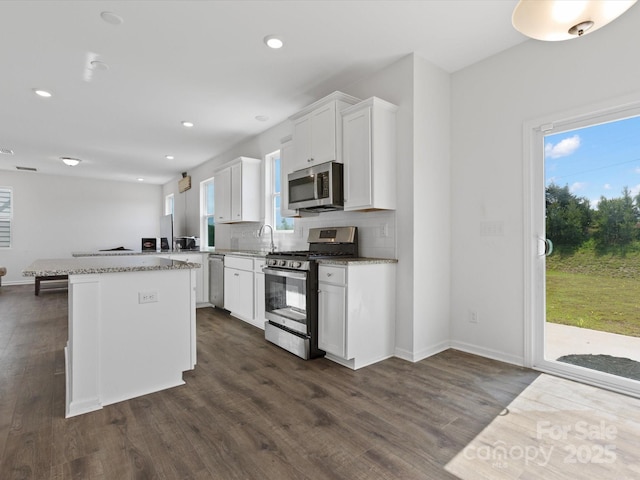 1433 Harleston St, Indian Trail, NC 28079 - kitchen with appliances with stainless steel finishes, a center island, dark wood-style floors, white cabinetry, and recessed lighting