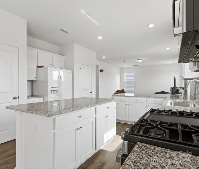 1433 Harleston St, Indian Trail, NC 28079 - kitchen featuring white fridge with ice dispenser, dark wood finished floors, white cabinetry, gas stove, and light stone countertops