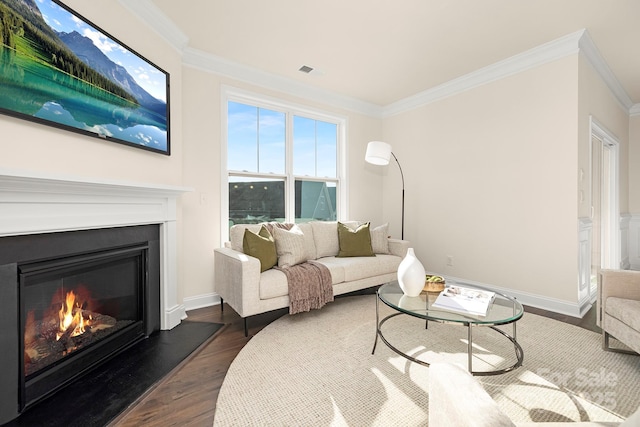 living room featuring dark wood finished floors, crown molding, a glass covered fireplace, and baseboards