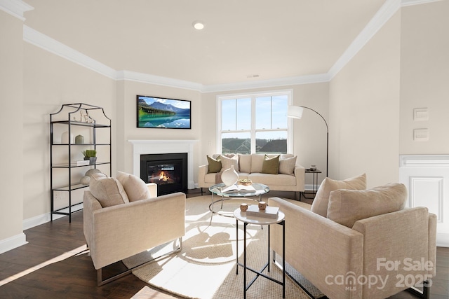 living area with ornamental molding, a glass covered fireplace, baseboards, wood finished floors, and recessed lighting