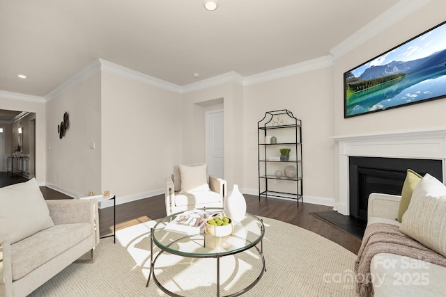 living room with wood finished floors, ornamental molding, recessed lighting, baseboards, and a fireplace with raised hearth