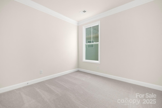 carpeted empty room with crown molding and baseboards
