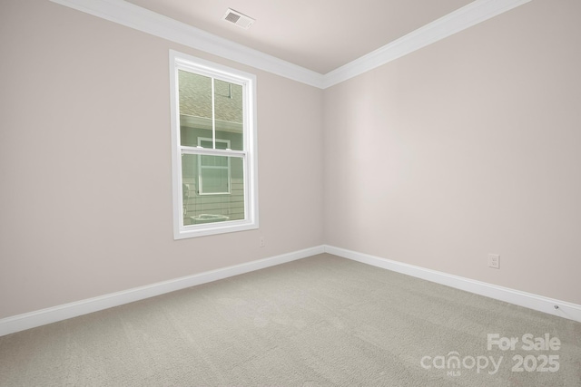carpeted empty room featuring crown molding and baseboards