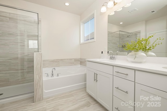 bathroom featuring a shower stall, a garden tub, double vanity, and recessed lighting