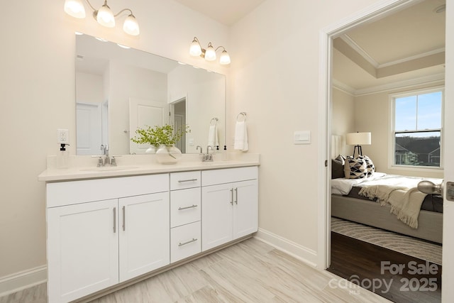 ensuite bathroom with baseboards, double vanity, and ornamental molding
