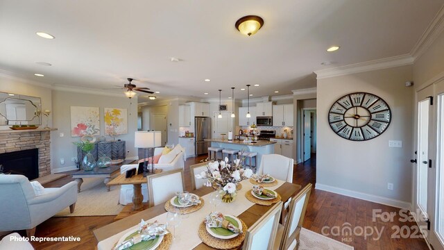 106 Noah Ln, Troutman, NC 28166 - dining space with ceiling fan, recessed lighting, dark wood-type flooring, crown molding, and a fireplace