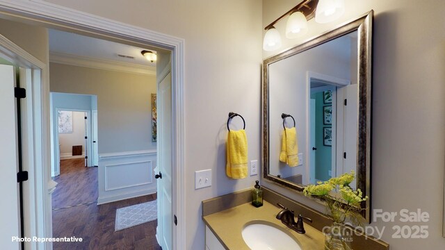 106 Noah Ln, Troutman, NC 28166 - bathroom featuring ornamental molding, vanity, wood finished floors, and wainscoting