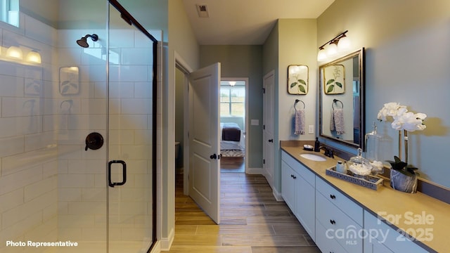 106 Noah Ln, Troutman, NC 28166 - ensuite bathroom featuring a stall shower, vanity, and wood finished floors
