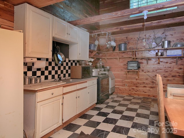 269 Johnson Dairy Rd, Mooresville, NC 28115 - kitchen with dark flooring, freestanding refrigerator, wooden walls, light countertops, and backsplash
