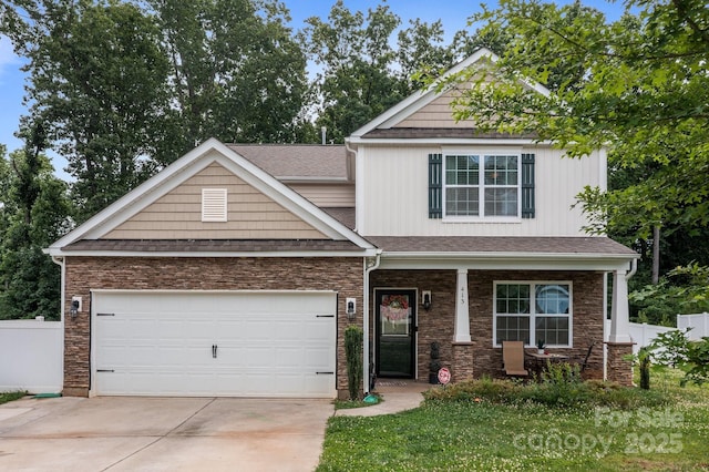 413 Wheat Field Dr, Mount Holly, NC 28120 - craftsman-style house with concrete driveway, covered porch, an attached garage, stone siding, and a shingled roof