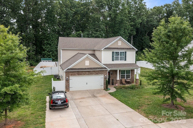 413 Wheat Field Dr, Mount Holly, NC 28120 - view of front of property featuring concrete driveway, an attached garage, a porch, roof with shingles, and stone siding