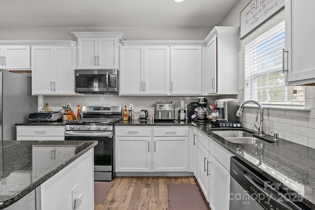 413 Wheat Field Dr, Mount Holly, NC 28120 - kitchen with stainless steel appliances, a sink, white cabinetry, dark wood-style flooring, and tasteful backsplash