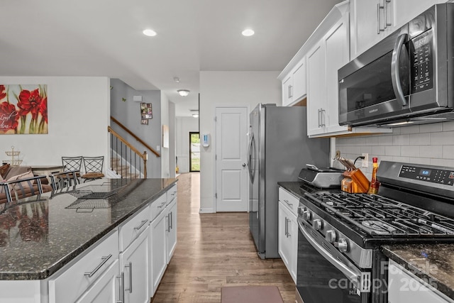 413 Wheat Field Dr, Mount Holly, NC 28120 - kitchen with appliances with stainless steel finishes, white cabinetry, backsplash, wood finished floors, and dark stone countertops
