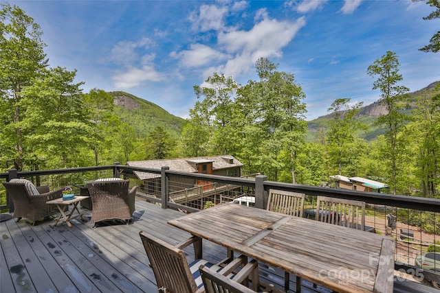 deck with outdoor dining area and a mountain view