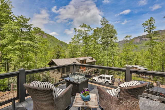 wooden terrace with a mountain view and a view of trees