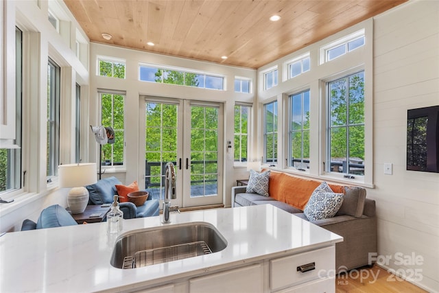 sunroom featuring french doors, a sink, and plenty of natural light