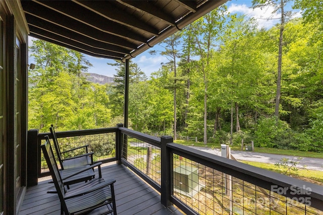 wooden terrace featuring a forest view