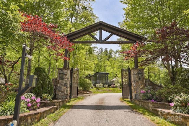 view of asphalt driveway featuring a gated entry
