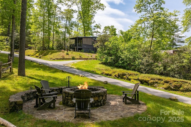 view of grassy yard featuring an outdoor fire pit