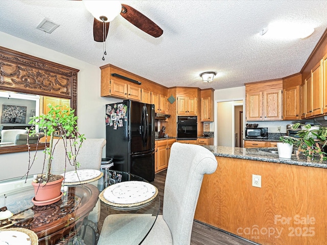 202 Cameron Dr, Kings Mountain, NC 28086 - kitchen with black appliances, dark wood finished floors, a ceiling fan, a peninsula, and a textured ceiling