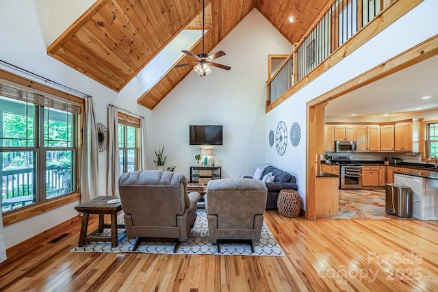 living area with light wood finished floors, high vaulted ceiling, ceiling fan, and recessed lighting