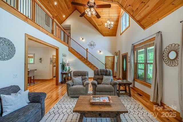 living room with wooden ceiling, light wood-style flooring, high vaulted ceiling, a chandelier, and a ceiling fan