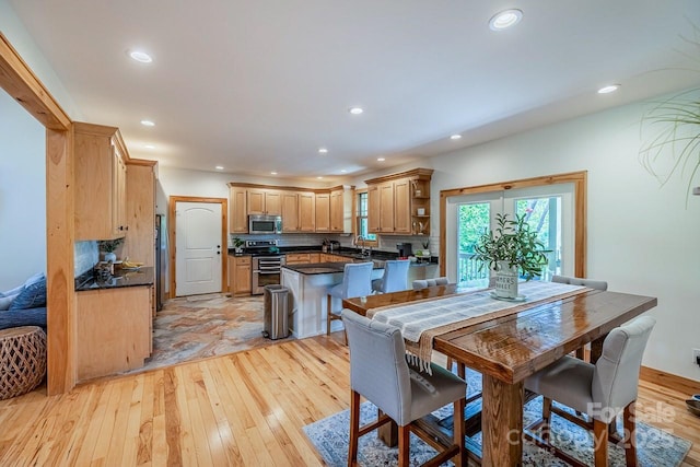 dining area with light wood-type flooring and recessed lighting