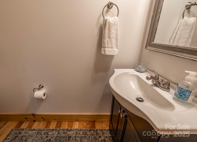 bathroom featuring wood finished floors, baseboards, and vanity