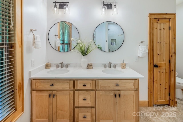 bathroom featuring toilet and double vanity