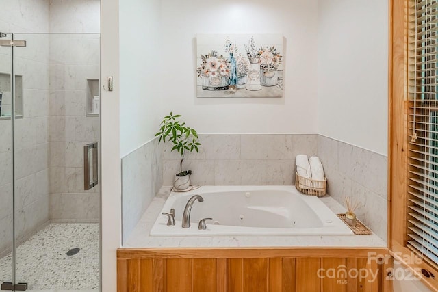 bathroom with a stall shower and a jetted tub
