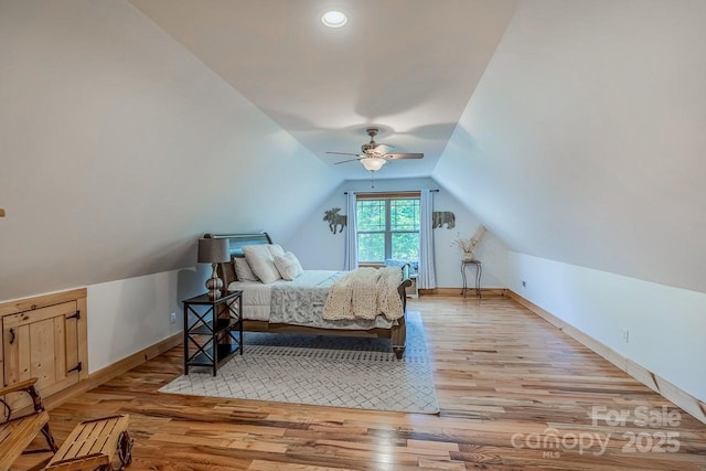 bedroom featuring lofted ceiling, light wood finished floors, and baseboards