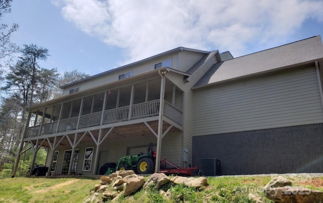 back of house featuring a sunroom and central air condition unit