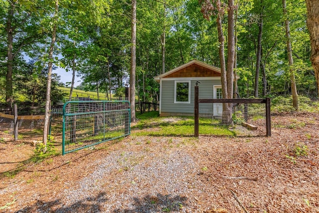 view of outbuilding featuring fence and an outdoor structure